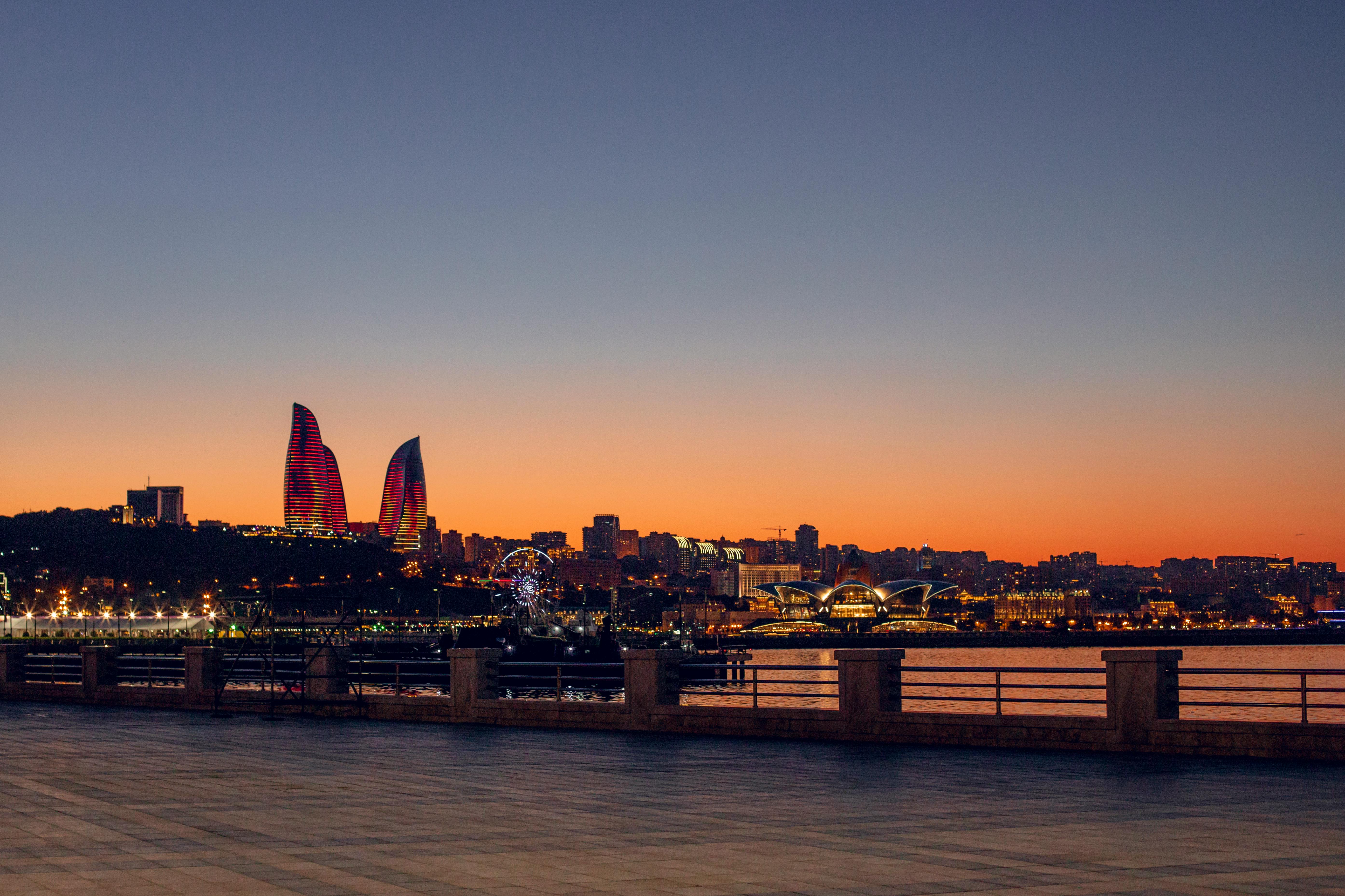 A breathtaking view of Baku's skyline with the iconic Flame Towers at sunset, highlighting the city's modern architecture.