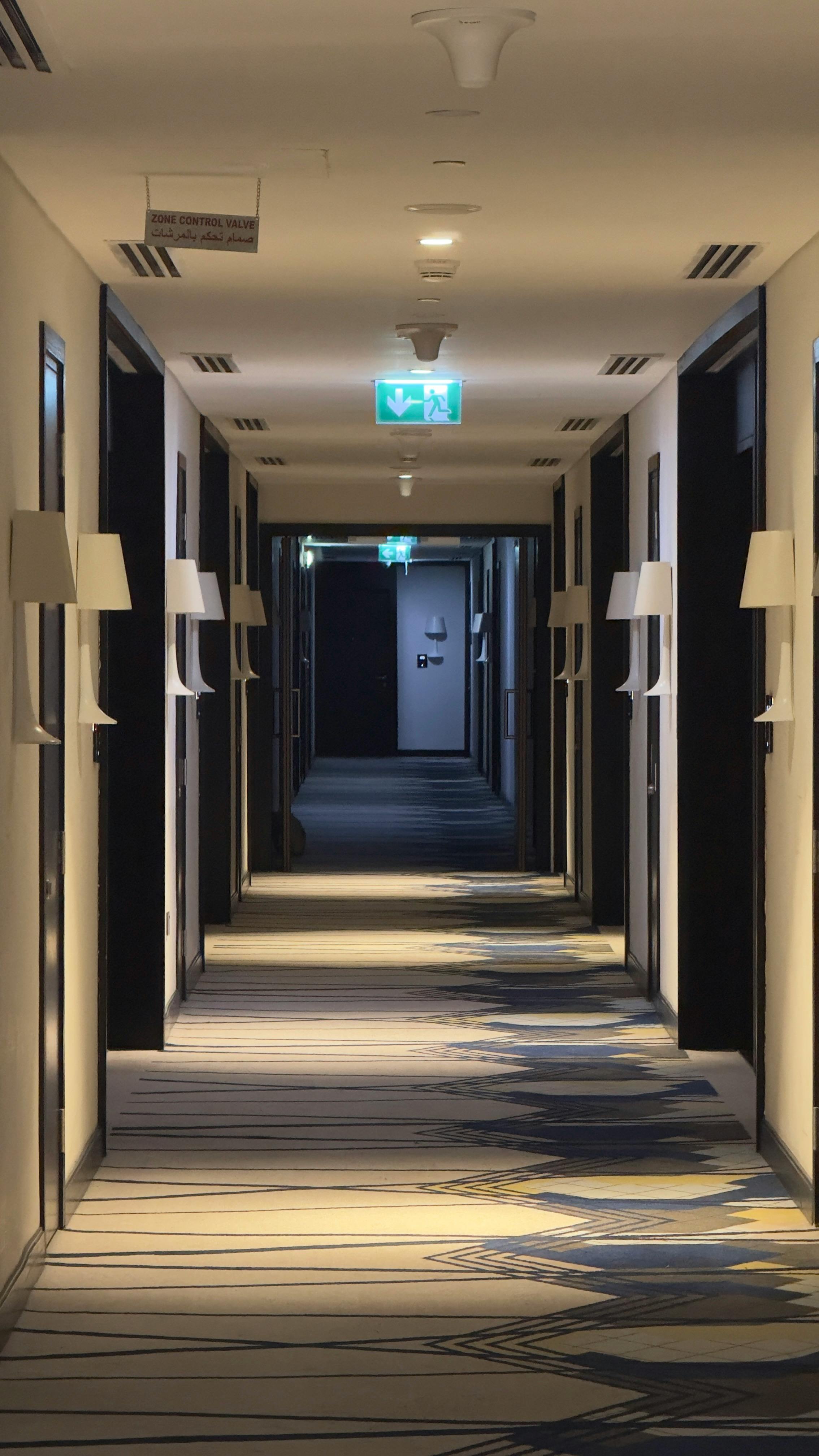 A luxurious hotel hallway in Dubai featuring modern lighting and an arched ceiling.