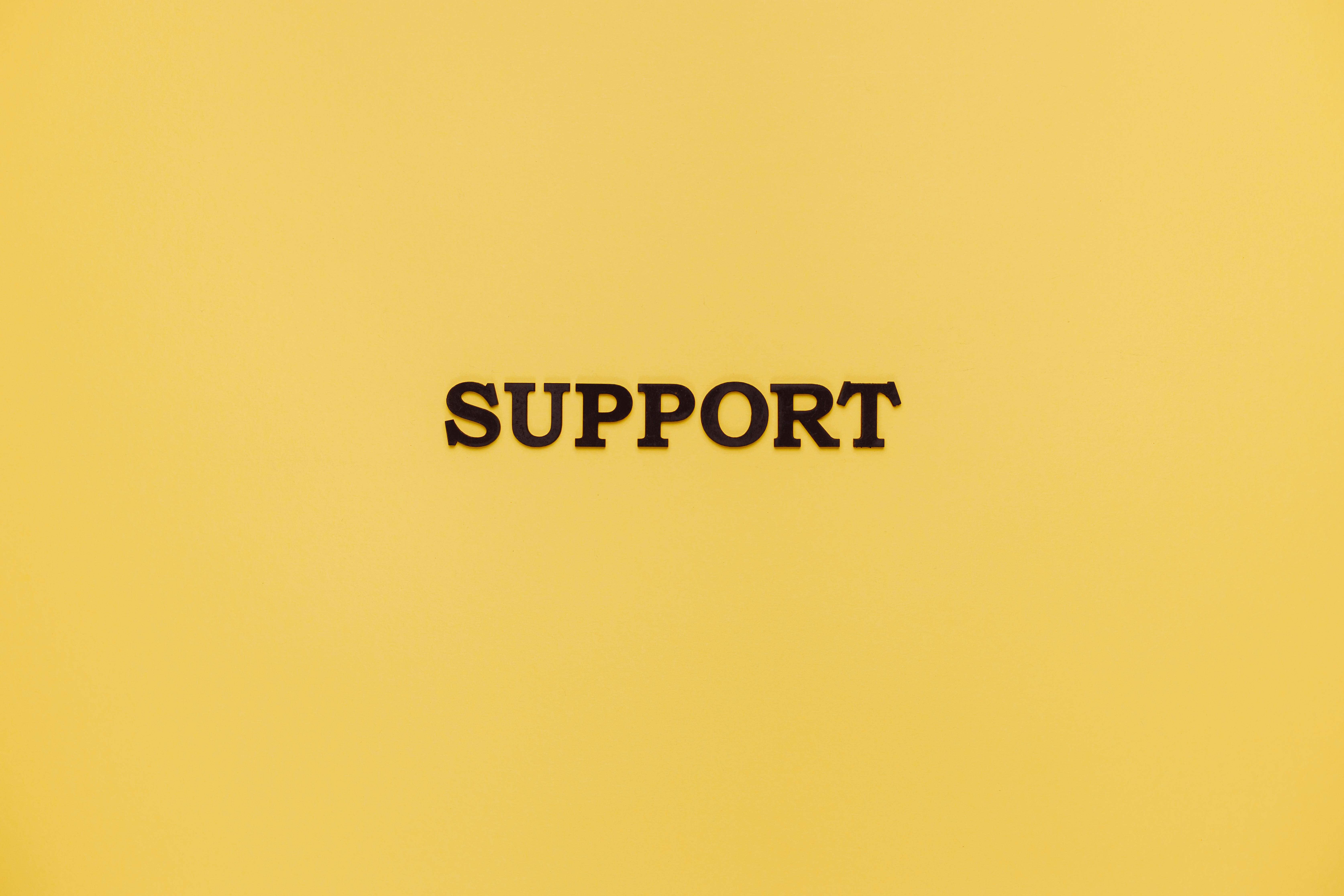 Minimalist image with 'Support' text on a yellow background for conceptual themes.